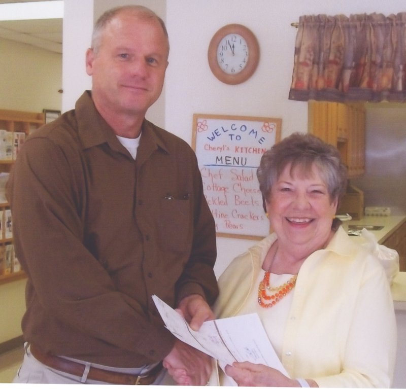 Submitted Photo Senator Jim Hendren presented a $15,000 check July 16 to Mary Kay Kelley, director of the Billy V. Hall Senior Activity Center. The funds were from the Northwest Arkansas Economic Development District, which has approved a General Improvement Fund grant. The GIF grant is a community development grant to the Office of Human Concern. Grant money will help the Billy V. Hall Center repair storm damage to the roof.