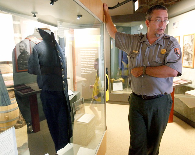 STAFF PHOTO JASON IVESTER Troy Banzhaf, park ranger and interpreter at Pea Ridge National Military Park, describes the Civil War frock worn by Lt. William B. Chapman during the Battle of Pea Ridge. The park recently obtained the coat via auction and put it on display in the museum last week.