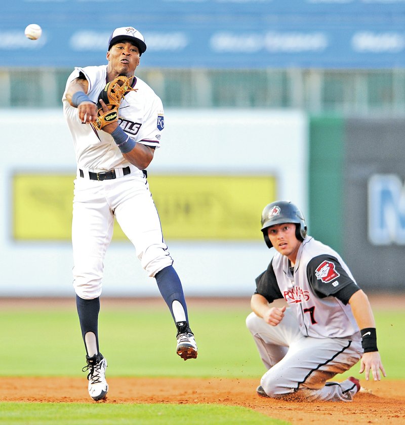  STAFF PHOTO ANDY SHUPE Justin Trapp, Northwest Arkansas Naturals second baseman, makes the relay throw to first after forcing out Arkansas Travelers second baseman Alex Yarbrough Tuesday to end the third inning at Arvest Ballpark in Springdale.