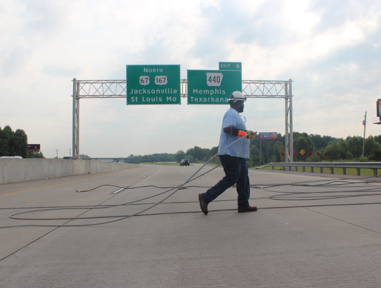 An Entergy worker clears lines that were knocked down across U.S. 67/167 Wednesday, blocking traffic in both directions.