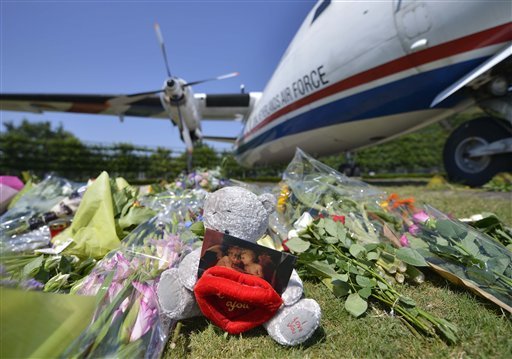 Flowers and a teddy bear are placed in front of a plane prior a ceremony to mark the return of the first bodies of passengers and crew killed in the downing of Malaysia Airlines Flight 17, from Ukraine at Eindhoven military air base, on Wednesday, July 23, 2014. After being removed from the planes, the bodies are to be taken in a convoy of hearses to a military barracks in the central city of Hilversum, where forensic experts will begin the painstaking task of identifying the bodies and returning them to their loved ones. 