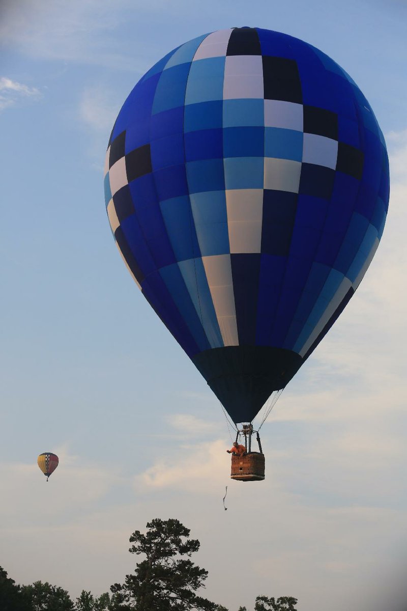 Arkansas Democrat-Gazette/RICK MCFARLAND --06/22/13-- Richard Sabin, of Longview, Tx., drops a bean bag at the target from his hot air balloon during the Great War Memorial Balloon Race in Little Rock Saturday. His was the first balloon to the target at War Memorial Golf Course. The other balloon shown was piloted by Sandy Graf, of Flowermound, Tx., and she was the only other balloon to drop at the target, though she was not as close as Sabin. The event continues Sunday. 