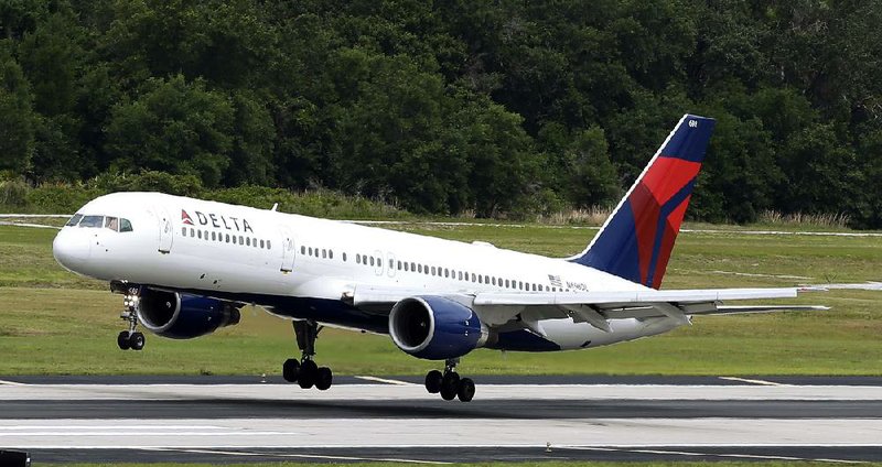 In this May 15, 2014 photo, a Delta Air Lines Boeing 757-232 lands at Tampa International Airport in Tampa , Fla. Delta reports quarterly financial results on Wednesday, July 23, 2014. (AP Photo/Chris O'Meara)