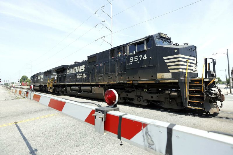 In this June 4, 2014 photo, a Norfolk Southern locomotive moves along the tracks in Norfolk, Va. Norfolk Southern Corp. on Wednesday, July 23, 2014 reported profit that climbed by 21 percent in its second quarter, and topped analysts' expectations. (AP Photo/Steve Helber)
