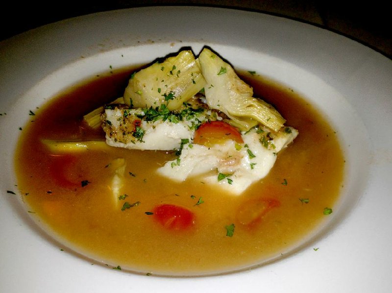 Tuscan-style Cod fillets with tomatoes, olives and artichoke hearts in a seafood broth at Ristorante Capeo.
