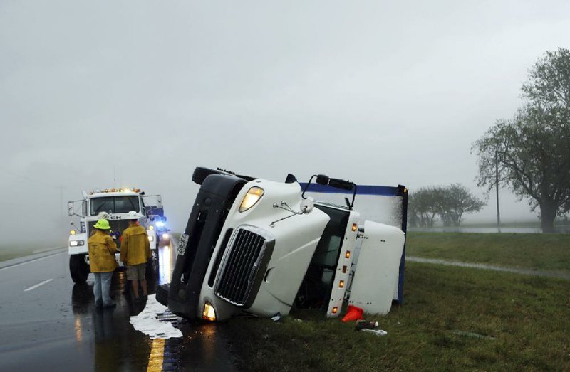 An overturned tractor trailer faces southbound along the U.S. Route 13 median in Northampton County, Thursday, July 24, 2014, near Cheriton, Va., after a severe storm swept through the area. (AP Photo/The Virginian-Pilot, Vicki Cronis-Nohe)  MAGS OUT