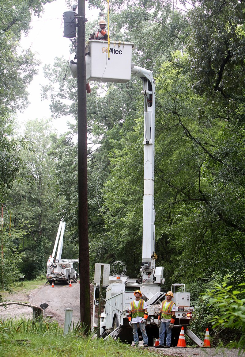 The Sentinel-Record/Richard Rasmussen RESTORING POWER: Entergy Arkansas Inc. crews worked Thursday morning to restore power to customers on Wilson Lake Road after severe thunderstorms moved through Garland County late Wednesday. About 8,500 Entergy customers were without power at the height of the outage, and some were still without service Thursday.
