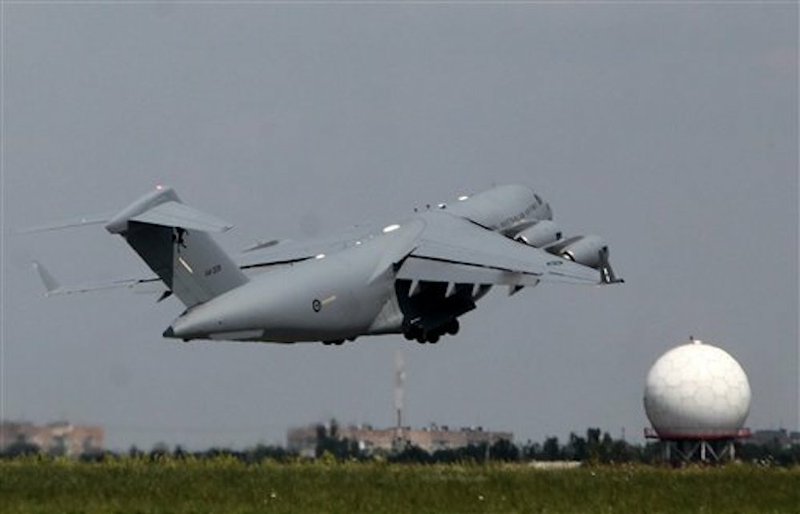 An Australian military cargo plane with coffins holding bodies of some of the passengers of the Malaysia Airlines jetliner that was downed last week over eastern Ukraine leaves for the Netherlands from Kharkiv airport, Ukraine, on Friday, July 25, 2014. 