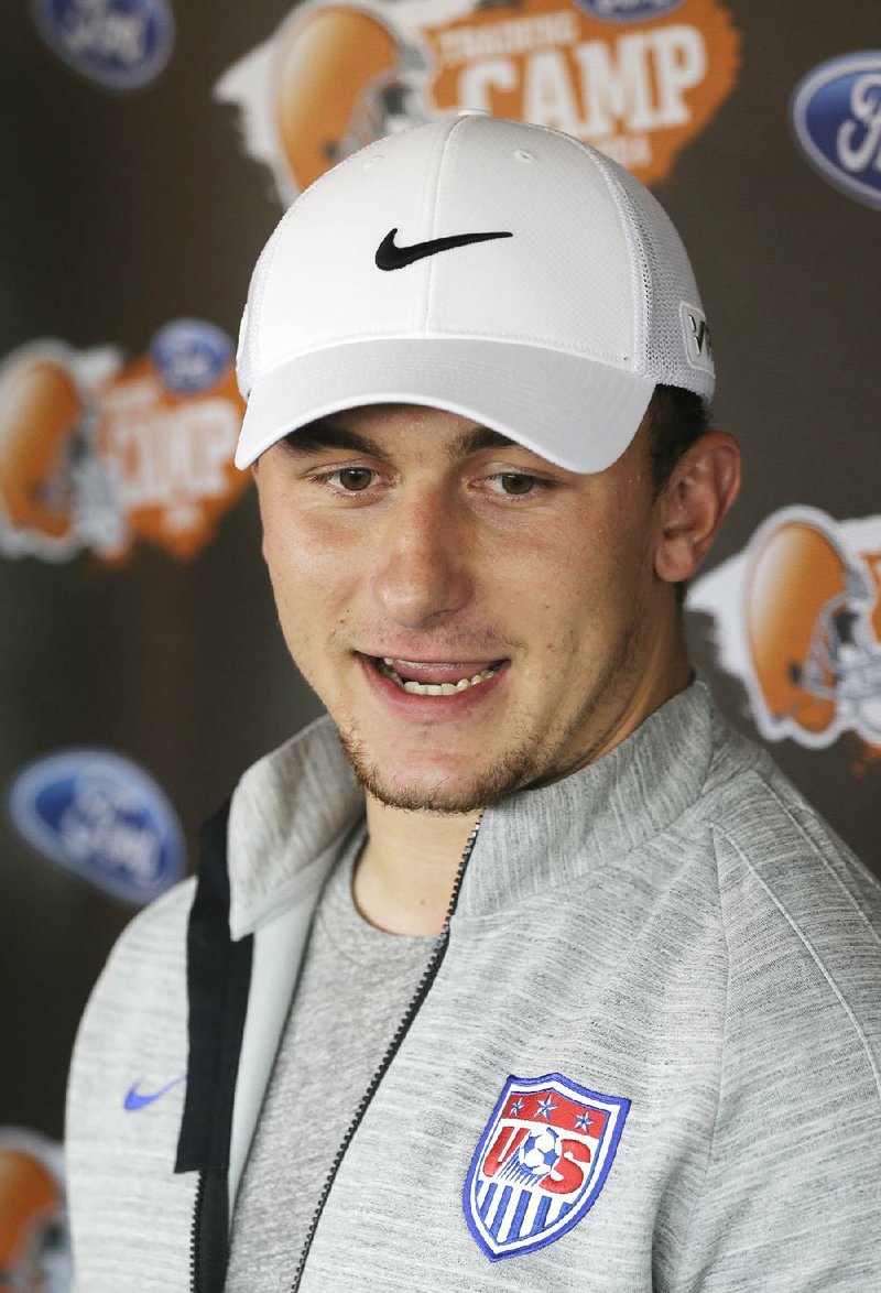 Cleveland Browns quarterback Johnny Manziel talks to reporters on the eve of the first practice at the NFL football team's training camp in Berea, Ohio, Friday, July 25, 2014. (AP Photo)