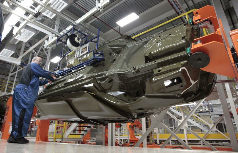 In this March 14, 2014 photo, an assembly line worker works on a 2015 Chrysler 200 automobile at the Sterling Heights Assembly Plant in Sterling Heights, Mich. The Commerce Department releases durable goods for June on Friday, July 25, 2014. (AP Photo/Paul Sancya)