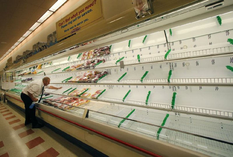 Meat manager Dave Fillebrown wipes down largely empty shelves at Market Basket in Haverhill, Mass., Thursday, July 24, 2014. Arthur T. Demoulas, the former chief executive of the Market Basket supermarket chain whose ouster has led to employee protests, customer boycotts and empty shelves, says he wants to buy the entire company. (AP Photo)