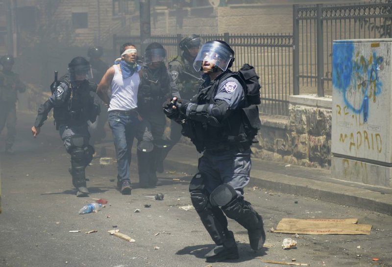 Israeli police officers detain a Palestinian man during clashes in the East Jerusalem neighborhood of Wadi Joz near Jerusalem's Old City on Friday, July 25, 2014. In Jerusalem, hundreds of Palestinians protested in the traditionally Arab-populated east of the city after Muslim noon prayers, and a dozen protesters threw rocks and fireworks at Israeli police, who fired stun grenades and water cannons. Thousands of Israeli security forces had been deployed for possible Palestinian protests. (AP Photo/Mahmoud Illean)