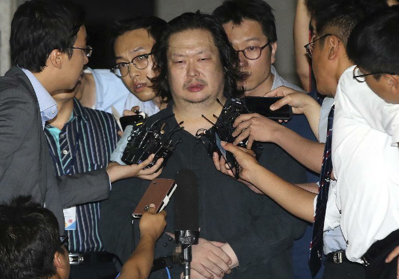 Yoo Dae-gyun, center, the eldest son of the sunken ferry owner, is surrounded by the reporters upon his arrival at Incheon District Prosecutors' Office in Incheon, South Korea, Friday, July 25, 2014. South Korean police detained Yoo after two months on the run, three days after his billionaire father was confirmed dead. (AP Photo/Yonhap, Han Jong-chan)  KOREA OUT