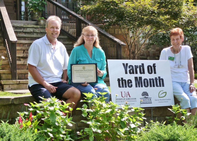 Submitted photo FROM NO LANDSCAPE TO LOTS: The home of Russ and Diane Daniel, left, was awarded the July Yard of the Month for Hot Springs Village by Valerie Nuckels, a member of Garland County Master Gardeners.