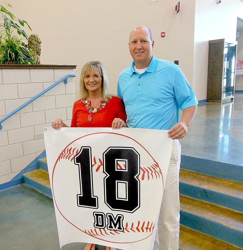 Submitted photo The Bismarck High School baseball and softball program has announced that it will host the inaugural Dusty McClard Classic in the spring of 2015. A portion of the proceeds will benefit the Dusty McClard Memorial Scholarship fund, established by the McClard family in memory of Dusty McClard, a former BHS student athlete from the Class of 2006. McClard&#8217;s mother, Paula Cook, left, displays his number with Brian Thornton, BHS volunteer assistant baseball coach.