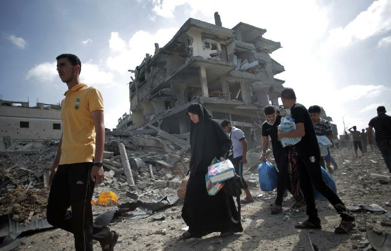 Palestinians who had fled their homes during Israeli airstrikes and artillery fire take advantage of a 12-hour cease-fire Saturday to stock up on supplies and salvage items from their damaged homes in the Shijaiyah neighborhood of Gaza City.