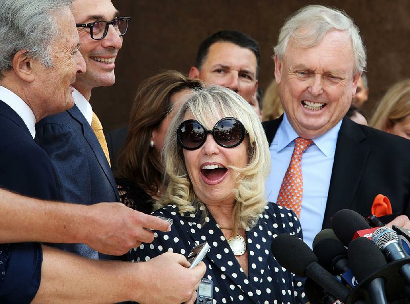 With her attorney Pierce O'Donnell, right, Shelly Sterling, center, talks to reporters after a judge ruled in her favor and against her estranged husband, Los Angeles Clippers owner Donald Sterling, in his attempt to block the $2 billion sale of the NBA basketball team, outside Los Angeles Superior Court, Monday, July 28, 2014. (AP Photo/Nick Ut)