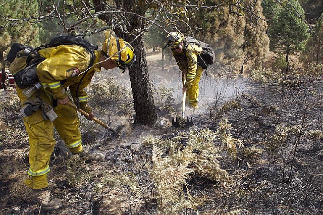 Cal Fire crew members mop up embers of the Sand Fire in the rugged foothills of El Dorado county near Plymouth, Calif., on Monday, July 28, 2014, 2014. (AP Photo/Steve Yeater)