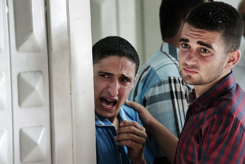 Palestinians grieve after identifying their loved one at the morgue of Gaza City's Shifa hospital, in the northern Gaza Strip, Monday, July 28, 2014. An explosion killed 10 people, 9 of them children, at a park at Shati refugee camp, in northern Gaza Strip. Israeli and Palestinian authorities traded blame over the attack and fighting in the war raged on despite a major Muslim holiday. (AP Photo/Lefteris Pitarakis)