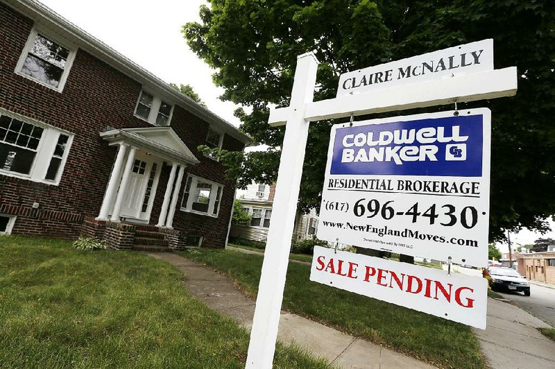 In this July 10, 2014 photo, a sale pending sign is posted in front of a home for sale in Quincy, Mass. The National Association of Realtors on Monday, July 28, 2014 said its seasonally adjusted pending home sales index slipped 1.1 percent to 102.7 in June. The index remains 7.3 percent below its level a year ago. (AP Photo/Michael Dwyer)