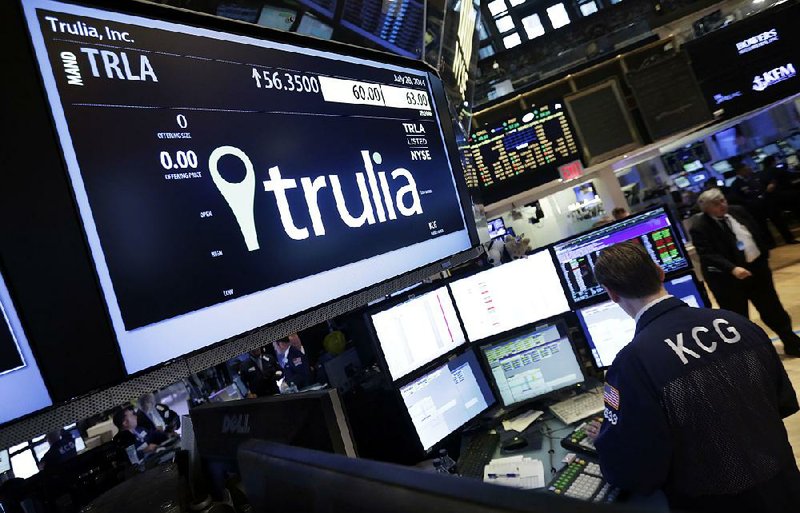 A specialist woks at the post that handles Trulia on the floor of the New York Stock Exchange, Monday, July 28, 2014. Trulia jumped 11 percent after the real-estate listing service Zillow said it plans to buy it for $3.5 billion. (AP Photo/Richard Drew)