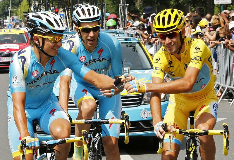 Tour de France winner Vincenzo Nibali of Italy (right) celebrates with his Astana teammates as they toast with glasses of champagne during the 21st and final stage of the annual race on Sunday, covering 85.4 miles from Evry, France, to the finish line in Paris.