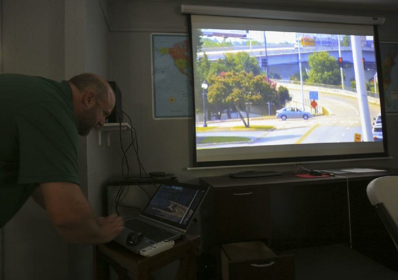Signal technician Jacob Mahan with the North Little Rock Traffic Department demonstrates the traffic cameras, including one showing the Main Street Bridge, that will be used to manage traffic • ow during the construction of a new Broadway Bridge.