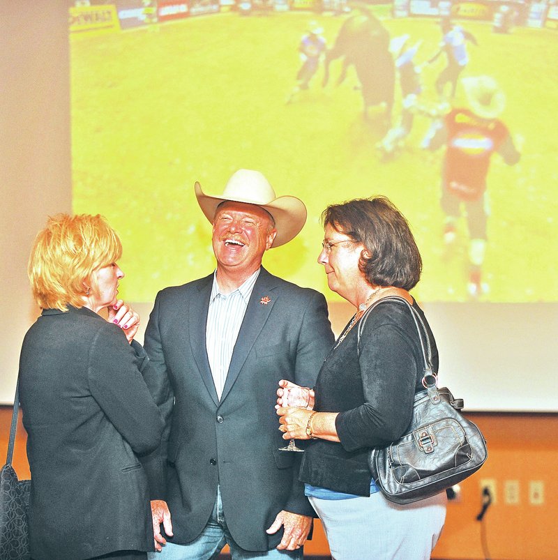 Staff Photo Michael Woods &#8226; @NWAMICHAELW Jim Haworth, center, chairman and chief executive officer of the Professional Bull Riders, talks with Barbara Brown, left, and Michelle Sem during a reception Monday at the John Q. Hammons Center in Rogers. The PBR is wanting to bring more of its events to Northwest Arkansas.