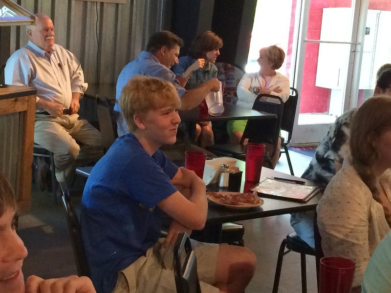 Cooper Lair, a 16-year-old Little Rock Christian Academy student, watches himself play in the Jeopardy! Teen Tournament semifinals on Tuesday at his watch party at Jim's Razorback Pizza in west Little Rock.