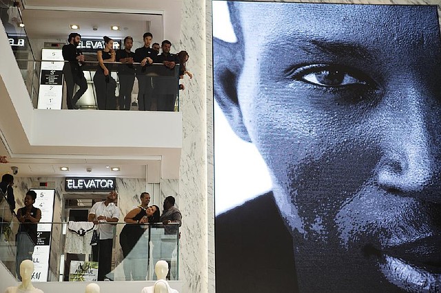 Employees at the new Hermes & Mauritz AB flagship store in New York look out from the store’s upper levels during a grand-opening ceremony July 17. The Conference Board said Tuesday that its consumer confidence index rose to 90.9 in July, the highest since October 2007, two months before the recession began.