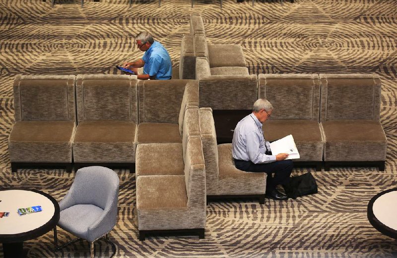 Doug Galloway (left), a lobbyist from Missouri, and Frank Simpson, a state senator from Oklahoma, take a break in the lobby of the Little Rock Marriott on Tuesday. Both men were in town for the annual meeting of the Southern Legislative Conference.