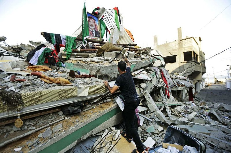 A Palestinian man searches through the rubble of the Gaza City home of Ismail Haniyeh, the top Hamas leader in Gaza, after an Israeli airstrike before dawn Tuesday. The house was one of dozens of targets that included Gaza’s only power plant and the offices of Hamas’ satellite television station.