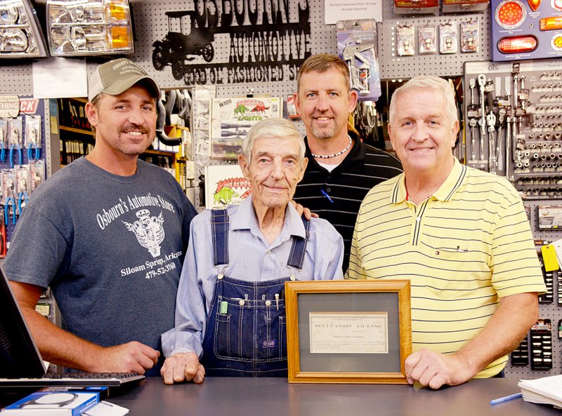 Janelle Jessen/Herald-Leader The three generations that run Osbourn&#8217;s Automotive stood together behind the counter holding the original business license dated 1947. Pictured are grandson Rex Osbourn, founder Don Osbourn, grandson Donny Osbourn and son Roger Osbourn.