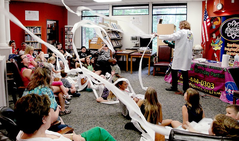 Courtesy of Diane S. Hine Warren Cox with Mad Science of NWA uses rolls of toilet paper and a blower to demonstrate science properties at a recent Summer Reading Program event at the Bella Vista Public Library.