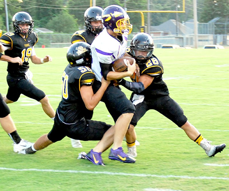 BEN MADRID ENTERPRISE-LEADER Conner West (left) and Logan Bartholomew wearing No. 26 wrap up a Lavaca ball-carrier. Both boys were tabbed as All-Conference selections in 2013.