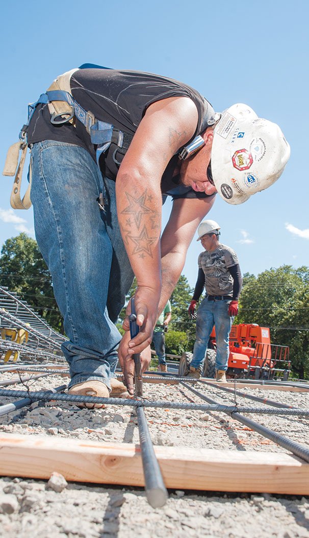 Ruben Diaz, an employee of Trilogy Concrete Construction Inc., ties rebar together to make a mat that will be used in the concrete foundation of the Heber Springs High School performing-arts complex. The $7 million building, estimated to be completed in November 2015, will include an approximately 1,000-seat auditorium to be used for the school and the community.