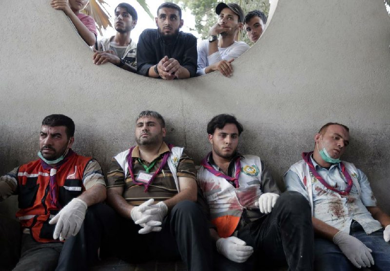 Palestinian medical workers take a break Wednesday at Shifa Hospital in Gaza City after carrying those wounded in an Israeli airstrike on a market in the Shijaiyah neighborhood.