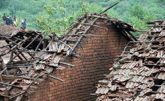 Rescuers arrive at a damaged house Wednesday as they look for survivors of a landslide that hit Malin village in western India.