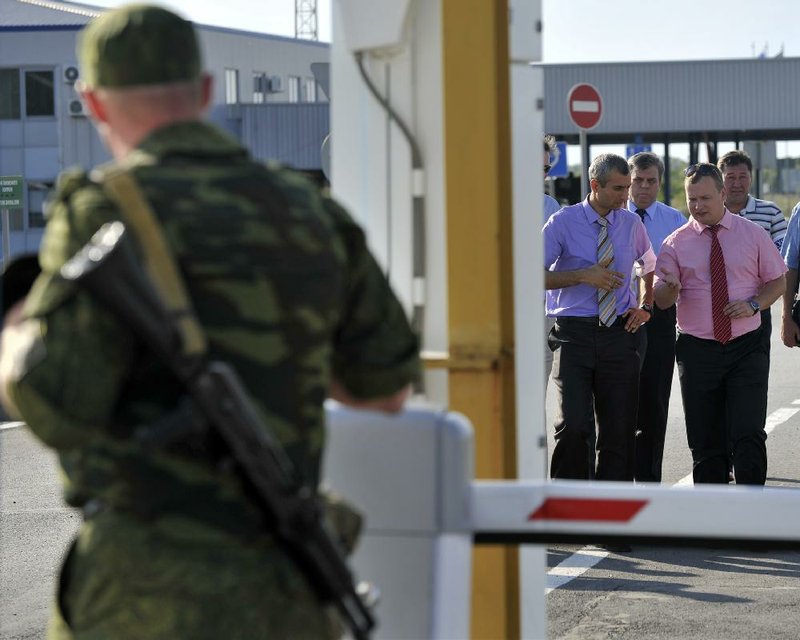 Paul Picard (second from right), acting chief observer for the Organization for Security and Cooperation in Europe, talks to other members of the organization Wednesday while visiting a checkpoint at the Russian-Ukrainian border in the town of Gukovo, Russia.