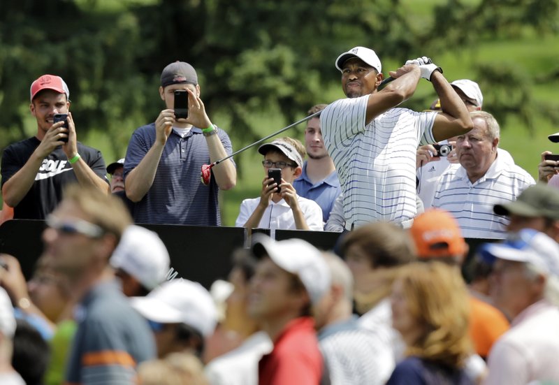 Tiger Woods watches his drive on the third hole during practice for the Bridgestone Invitational golf tournament Wednesday, July 30, 2014, in Akron, Ohio. 