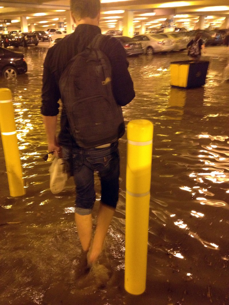 In this Tuesday, July 29, 2014 photo, a person walks through a flooded parking structure at UCLA after a ruptured 93-year-old, 30-inch water main left the Los Angeles campus awash in 8 million gallons of water in the middle of California's worst drought in decades. The water also flooded the school's storied basketball court, which underwent a major renovation less than two years ago.