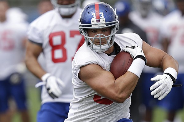 New York Giants' Peyton Hillis runs the ball during a NFL football camp in East Rutherford, N.J., Wednesday, July 23, 2014. (AP Photo/Seth Wenig)