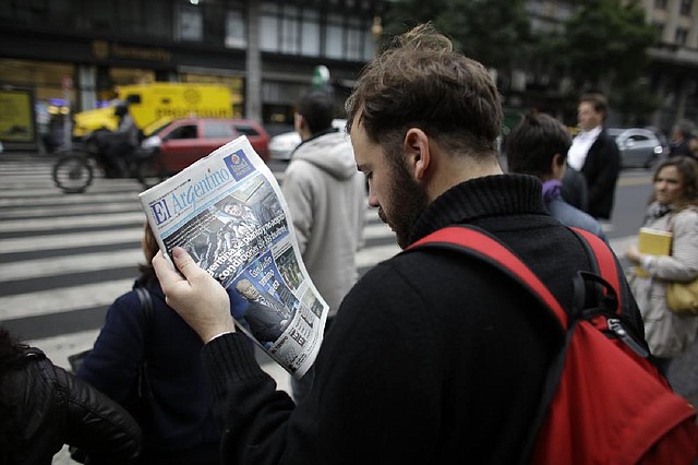 A man reads a newspaper with a headline that reads in Spanish; "Argentina didn't accept the conditions of the vultures," in reference to the dispute of Argentina over $1.5 billion with a U.S. hedge fund, known locally as "vulture funds," in Buenos Aires, Argentina, Thursday, July 31, 2014. The collapse of talks with U.S. creditors sent Argentina into its second debt default in 13 years and raised questions about what comes next for financial markets and the South American nation's staggering economy. (AP Photo/Victor R. Caivano)