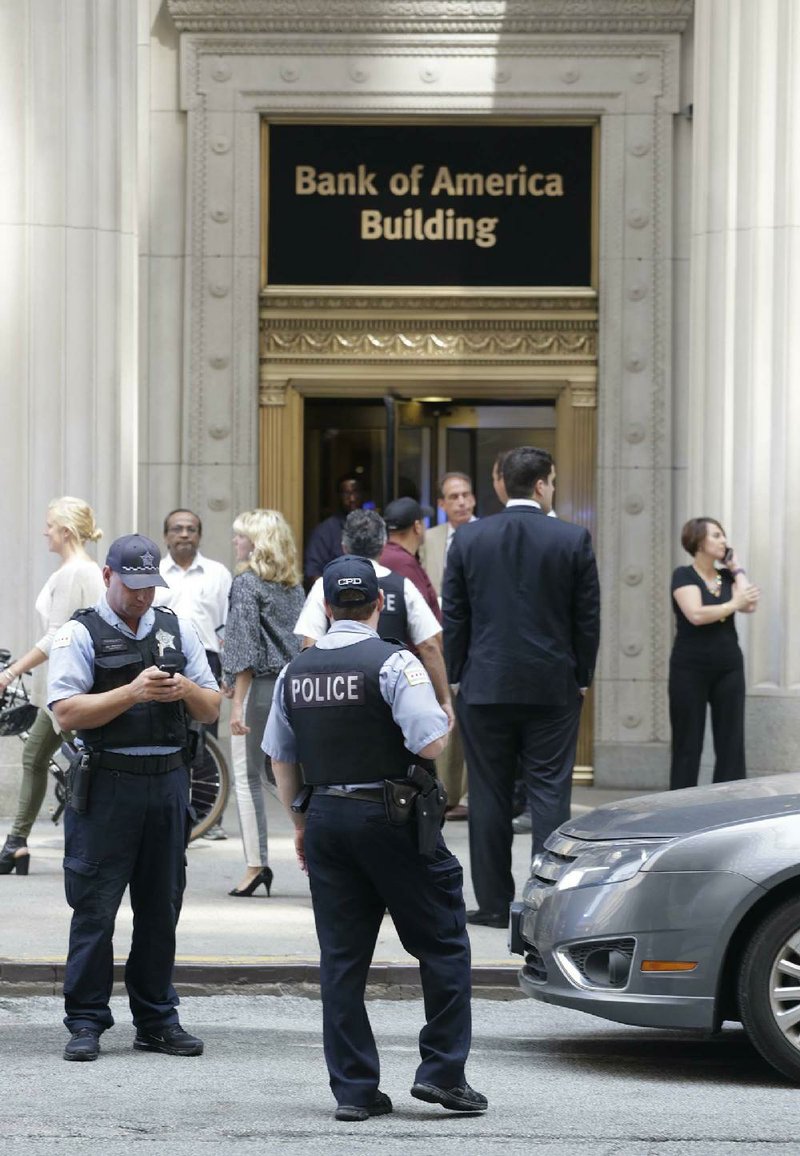 Chicago police stand outside a downtown high-rise office building following a shooting inside the building, Thursday, July 31, 2014. Police said a demoted worker shot and critically injured his company's CEO before fatally shooting himself. (AP Photo/M. Spencer Green)