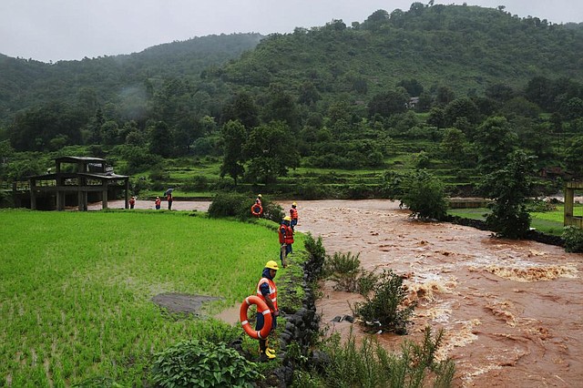 Rescue workers stand on the bank of a river as they look for bodies after a major landslide in Malin village in Pune district of western Maharashtra state, India, on Thursday.