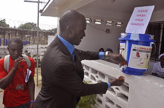 A man washes his hands Thursday before entering a public building in Monrovia, Liberia, as part of a drive to prevent further spread of the deadly Ebola virus.