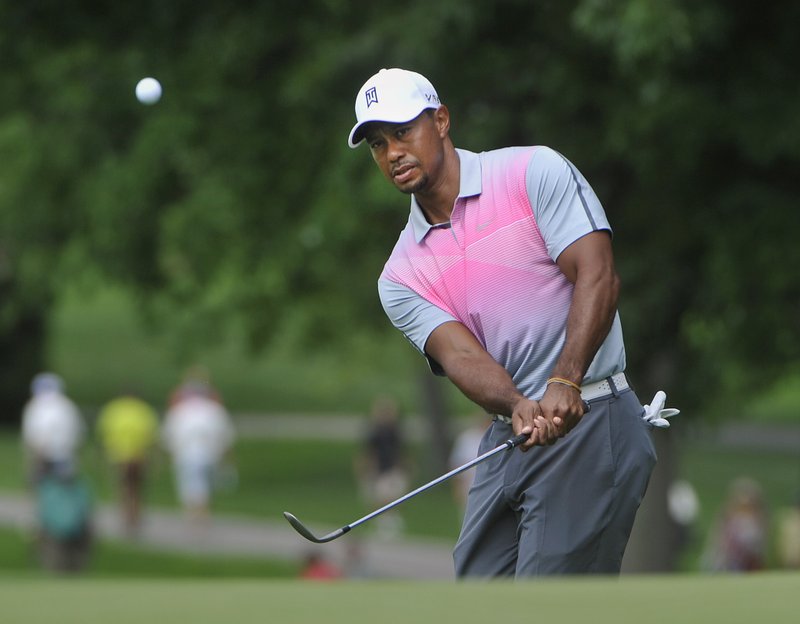 Tiger Woods watches his chip to the fourth hole, during the first round of the Bridgestone Invitational golf tournament, Thursday, July 31, 2014, in Akron, Ohio.