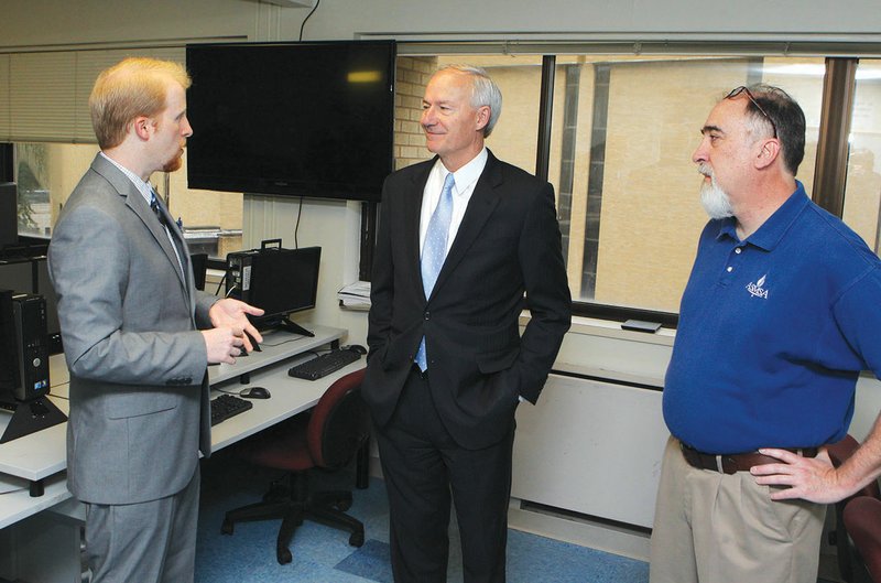 The Sentinel-Record/Richard Rasmussen CANDIDATE VISIT: Republican gubernatorial candidate Asa Hutchinson, center, speaks with Corey Alderdice, left, director of the Arkansas School for Mathematics, Sciences, and the Arts, and Bob Gregory, dean of academic affairs, on Thursday in the school's Meade Digital Arts Lab. The group spent much of the campus tour discussing opportunities for students in computer education.