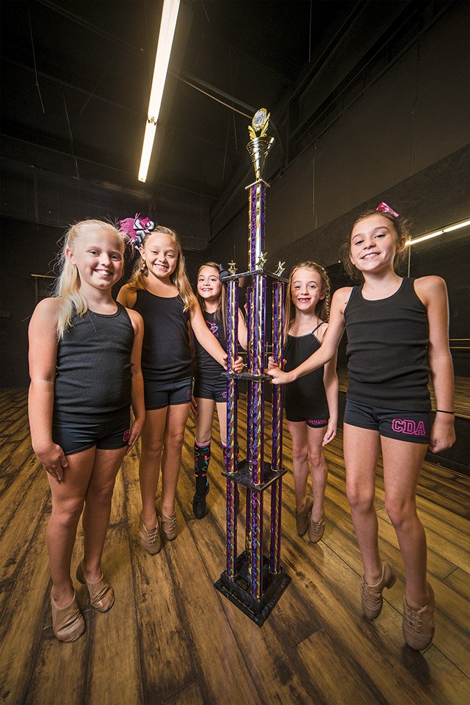 Rusty Hubbard/Three Rivers Edition
Cabot Dance Academy students Jayden Cloinger, from left, Jersey Grace Petross, Skye Epley, Brooke Davis and Ashley Drees stand on the tips of their toes but can’t equal the height of the massive trophy they won for tap dancing at the 2014 Talent on Parade National Finals held in Overland Park, Kan., July 9-13.