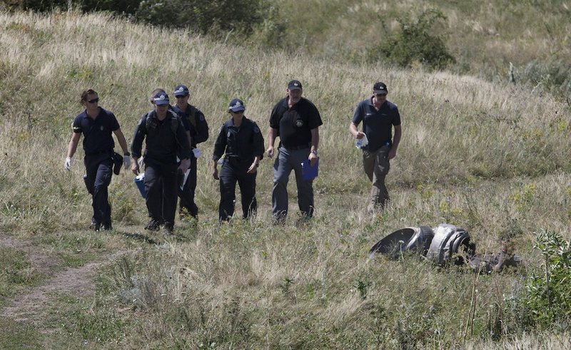 Australian experts examine the area of the Malaysia Airlines Flight 17 plane crash in the village of Hrabove, Donetsk region, eastern Ukraine on Friday, Aug. 1, 2014. The head of the Dutch-led international team investigating the Malaysian Airline Flight 17 disaster says his group has retrieved additional DNA samples from 25 victims at a mortuary in Donetsk in eastern Ukraine. 